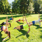 group of happy friends exercising outdoors